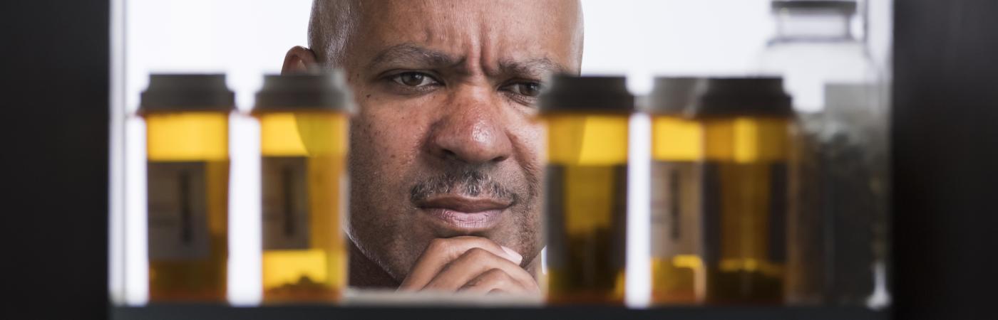 man looking in to medicine cabinet