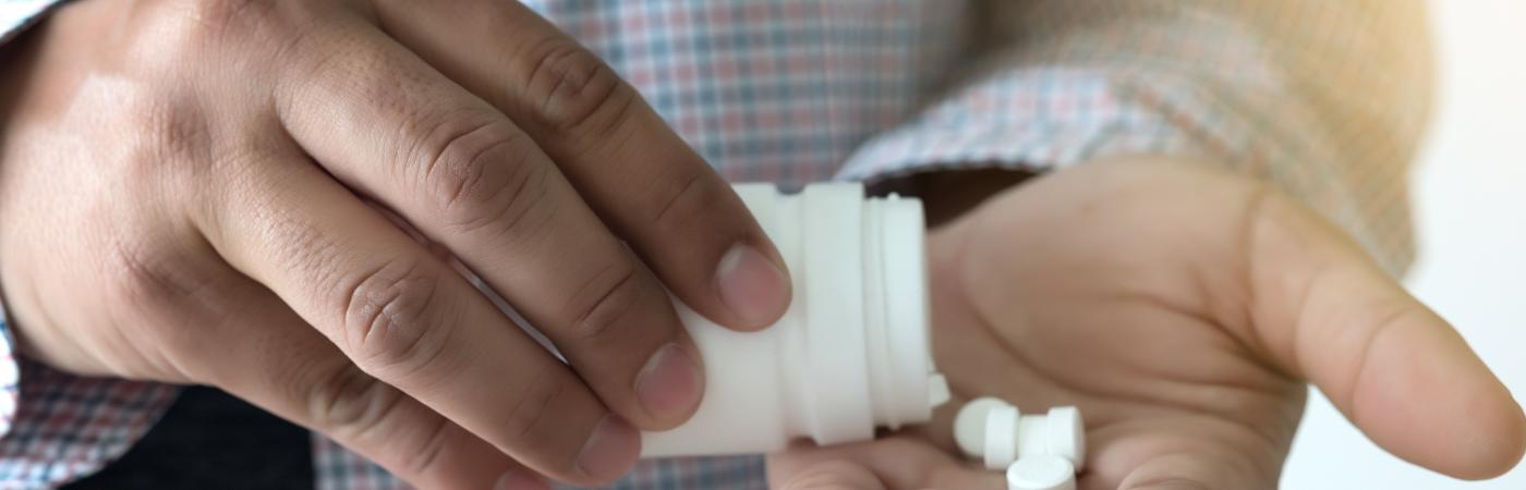 person pouring pills into hand