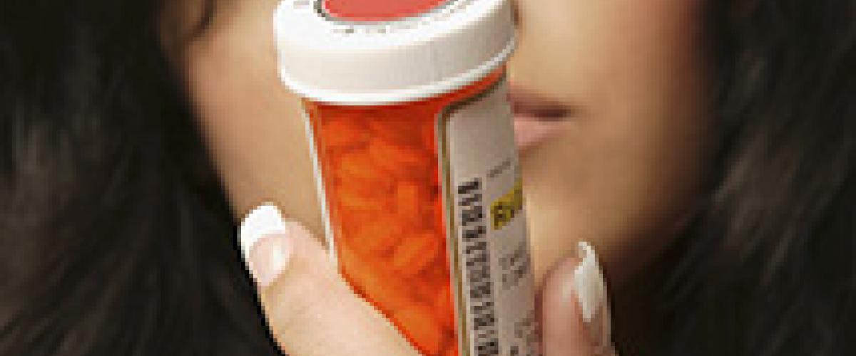 woman looking at prescription bottle