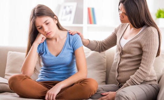 Daughter and mother talk on the sofa