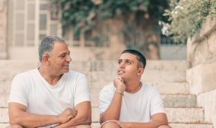 father talking to son on porch