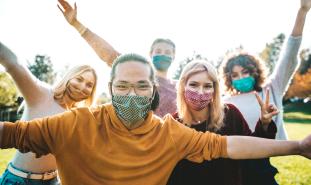 happy friends handing out outside with masks