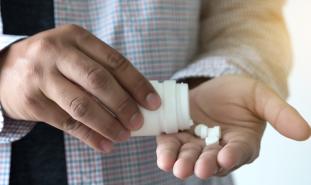 person pouring pills into hand