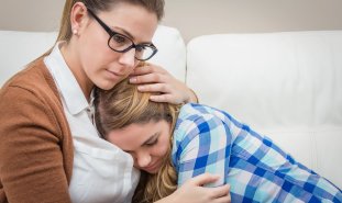 Mother hugs daughter