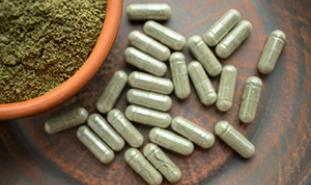 kratom pills and powder on a table