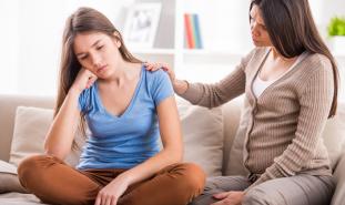 Daughter and mother talk on the sofa