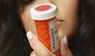 woman looking at prescription bottle