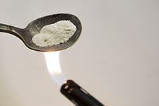 white powder in spoon over lighter